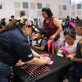 Family stops by partner booth during Back to School Bash to receive free school supplies at Palm View Branch Community Center's Gym.