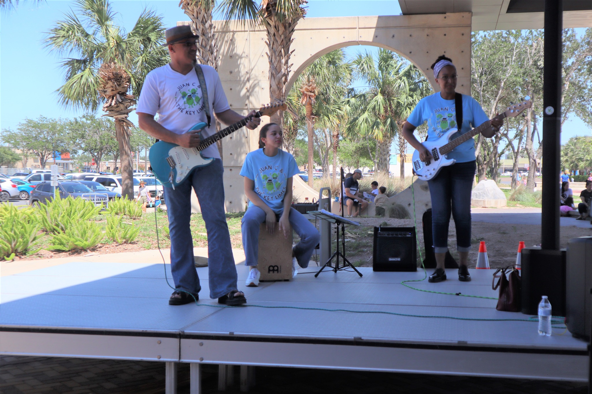 Band performs live on the outdoor stage at Main Library, playing guitars and percussion during a community event.