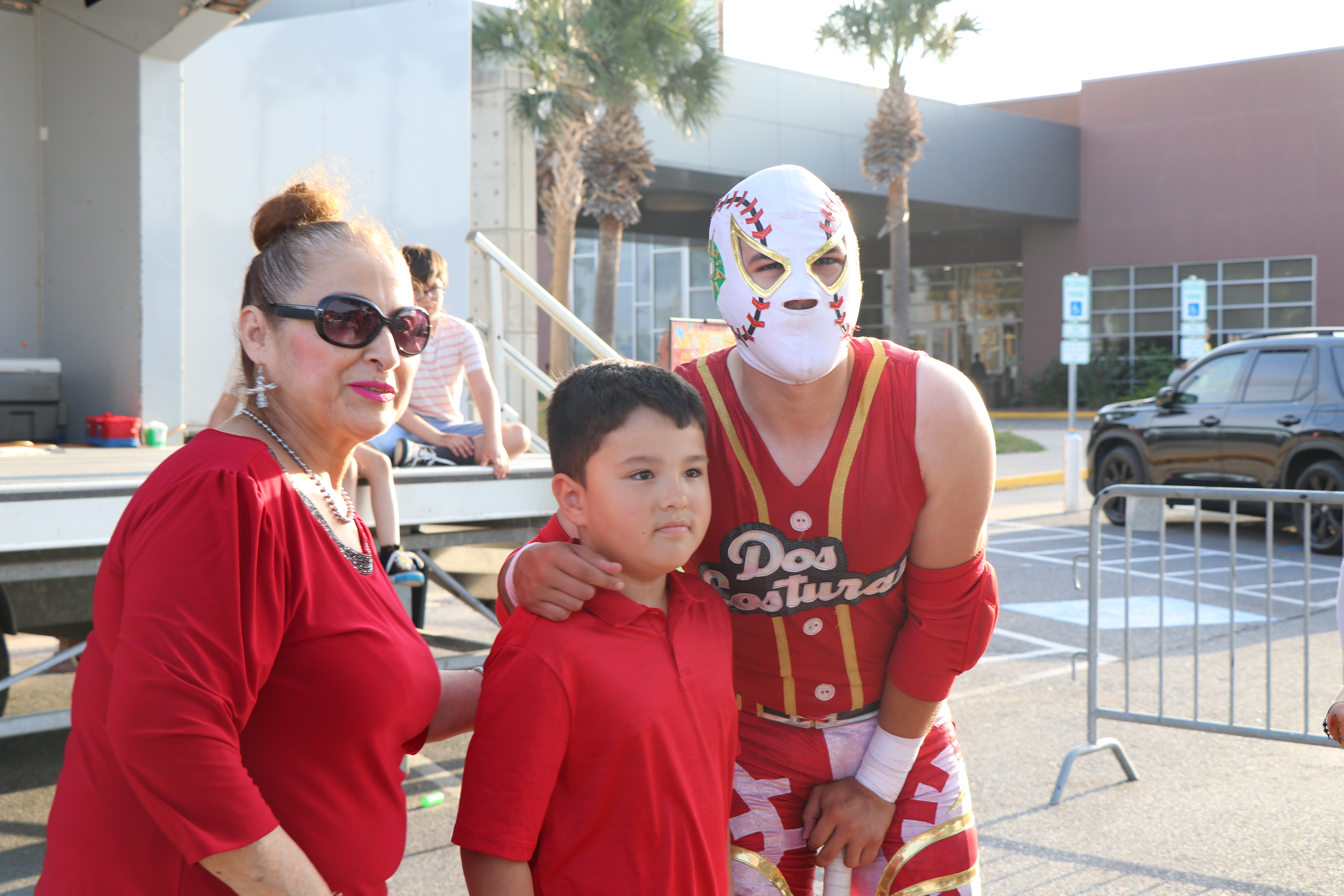 Family poses with a masked luchador during the Día de los Niños celebration at Main Library.